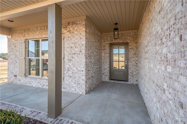 doorway to property featuring brick siding