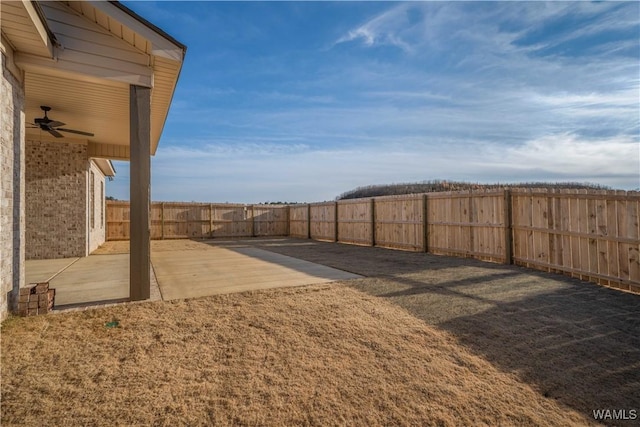 view of yard featuring a fenced backyard, a ceiling fan, and a patio