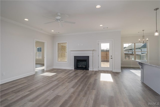 unfurnished living room featuring baseboards, a fireplace, dark wood-style flooring, and ornamental molding