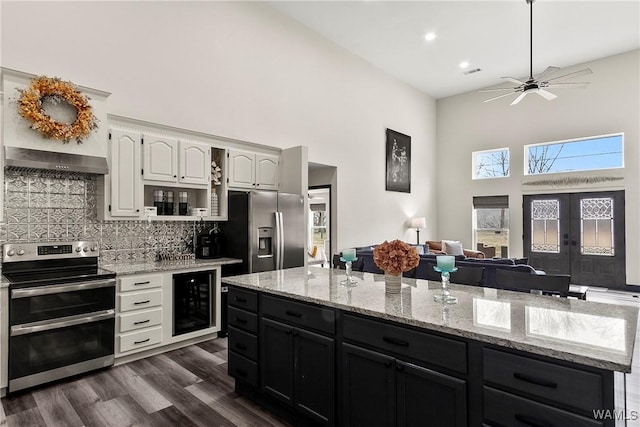 kitchen with decorative backsplash, dark wood-style floors, wine cooler, appliances with stainless steel finishes, and white cabinetry