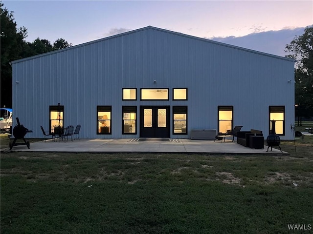 back of property at dusk featuring a patio area and a yard