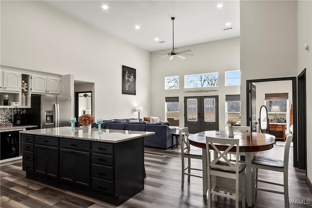 kitchen with french doors, open floor plan, white cabinetry, ceiling fan, and stainless steel fridge