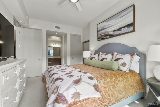 carpeted bedroom featuring ceiling fan and ensuite bath