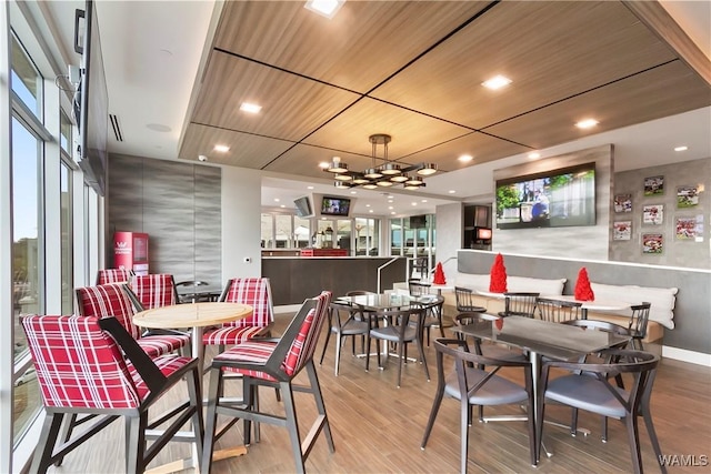 dining space featuring a chandelier, wooden ceiling, and light hardwood / wood-style floors