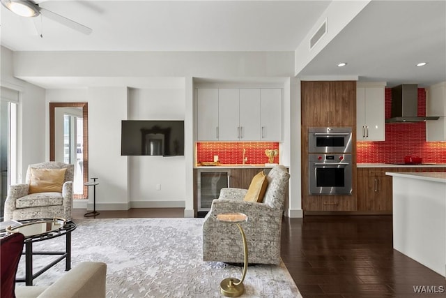 living room with ceiling fan, beverage cooler, and dark hardwood / wood-style flooring