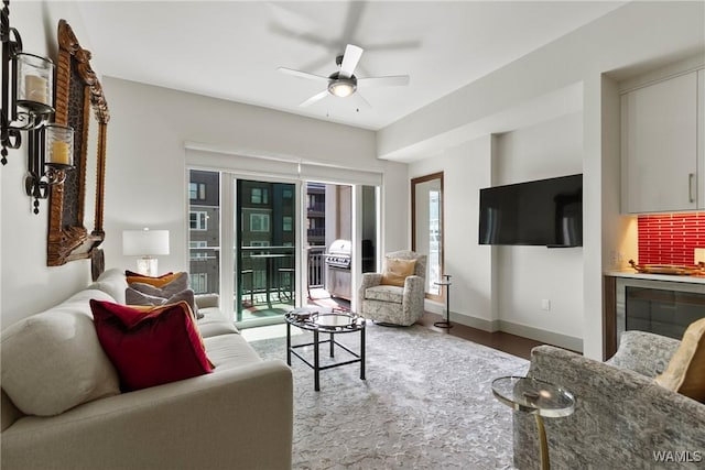 living room featuring ceiling fan, wood-type flooring, and a healthy amount of sunlight