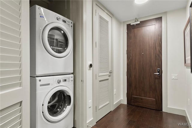 laundry area featuring stacked washer and clothes dryer and dark hardwood / wood-style flooring