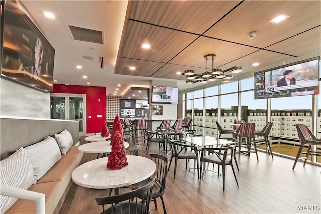 dining room featuring a wall of windows, wooden ceiling, a chandelier, and wood-type flooring