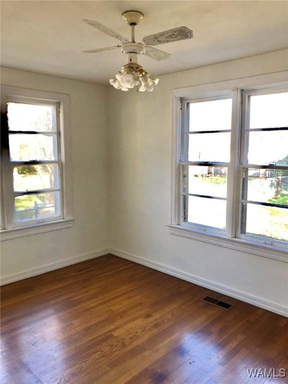 empty room with ceiling fan and dark wood-type flooring