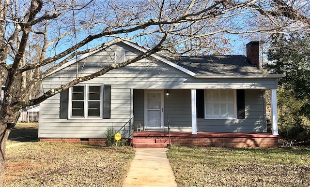 bungalow with a front lawn and covered porch