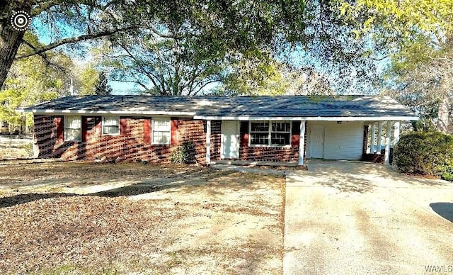 ranch-style home with an attached carport, concrete driveway, and brick siding