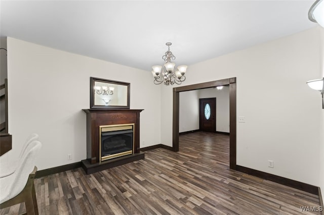 unfurnished living room with dark hardwood / wood-style flooring and an inviting chandelier