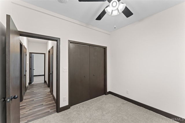 unfurnished bedroom featuring hardwood / wood-style flooring, ceiling fan, and a closet