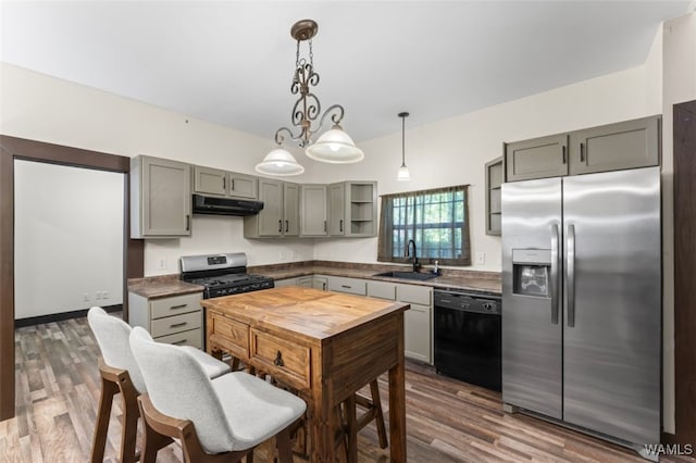 kitchen featuring gray cabinetry, sink, dark wood-type flooring, stainless steel appliances, and decorative light fixtures