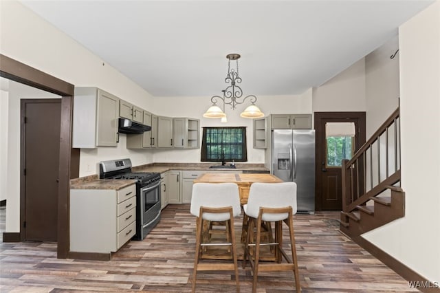 kitchen with appliances with stainless steel finishes, decorative light fixtures, dark wood-type flooring, and gray cabinetry