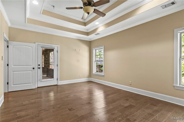 spare room featuring a raised ceiling, crown molding, and visible vents