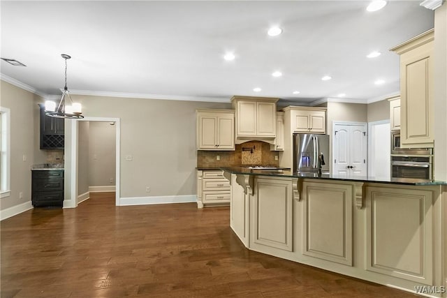 kitchen featuring ornamental molding, dark countertops, a breakfast bar, cream cabinetry, and stainless steel appliances