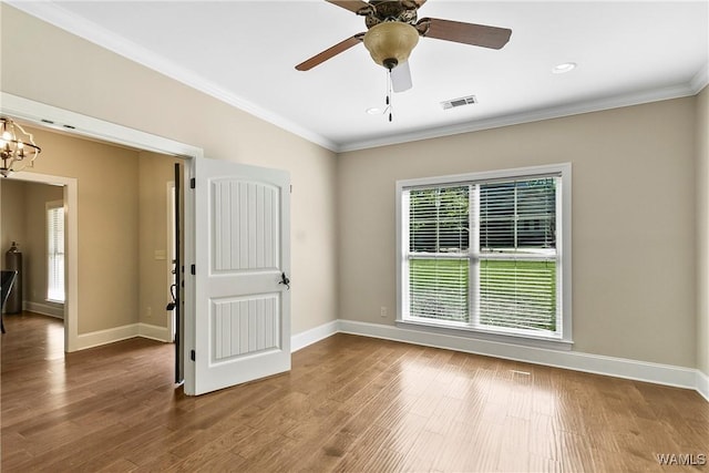 unfurnished room featuring crown molding, visible vents, and plenty of natural light