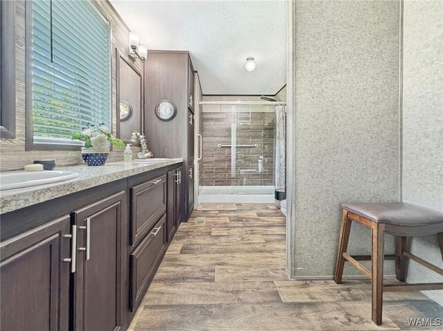 234 Broad Leaf Cir, Moundville, AL 35474 - full bathroom featuring a shower stall, wood finished floors, double vanity, and a textured ceiling