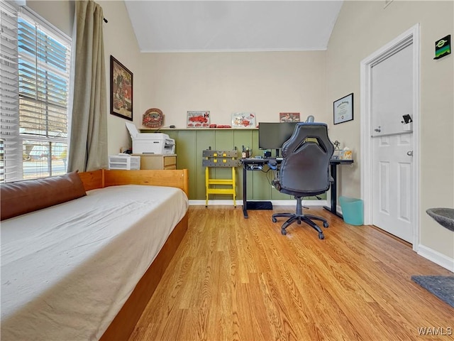 bedroom with vaulted ceiling and light hardwood / wood-style floors