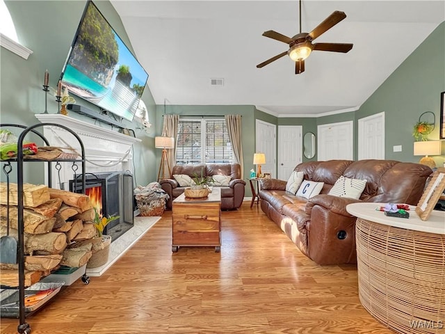 living room featuring light wood-type flooring, ceiling fan, and lofted ceiling