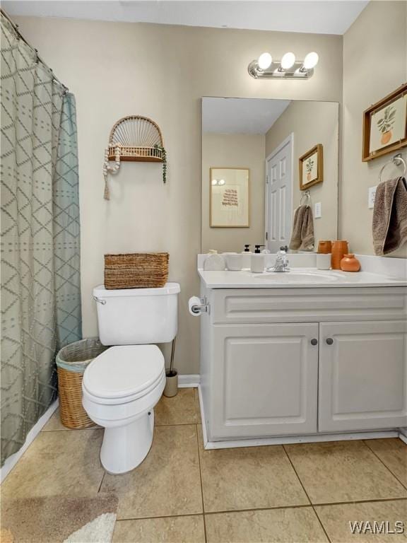 bathroom with toilet, vanity, and tile patterned floors