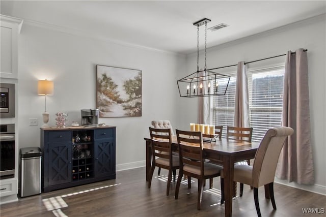 dining space with a chandelier, crown molding, and dark hardwood / wood-style floors