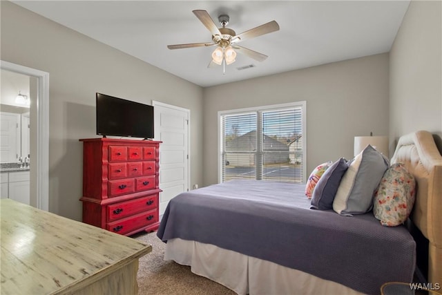 bedroom featuring carpet floors, ensuite bath, and ceiling fan