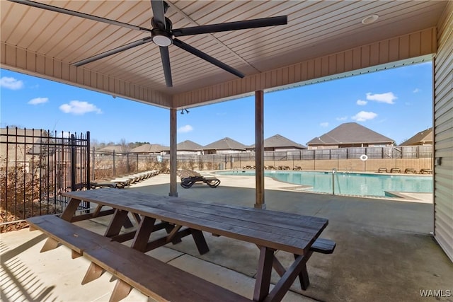 view of patio with a community pool and ceiling fan