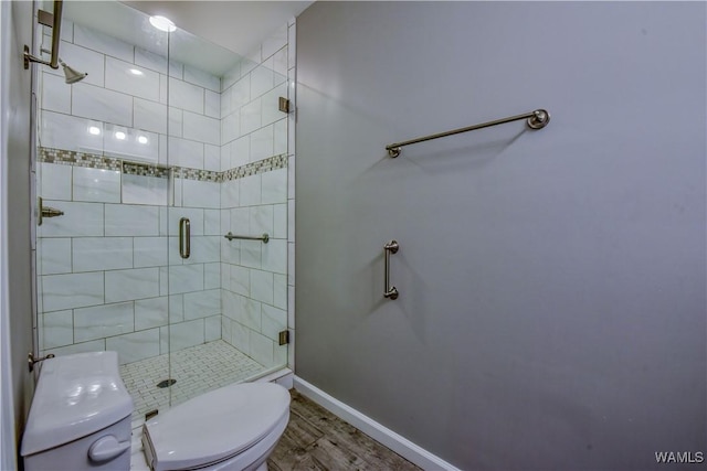 full bathroom featuring wood finished floors, baseboards, toilet, and a stall shower