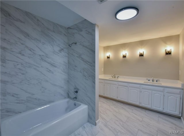 full bathroom with bathtub / shower combination, double vanity, marble finish floor, and a sink