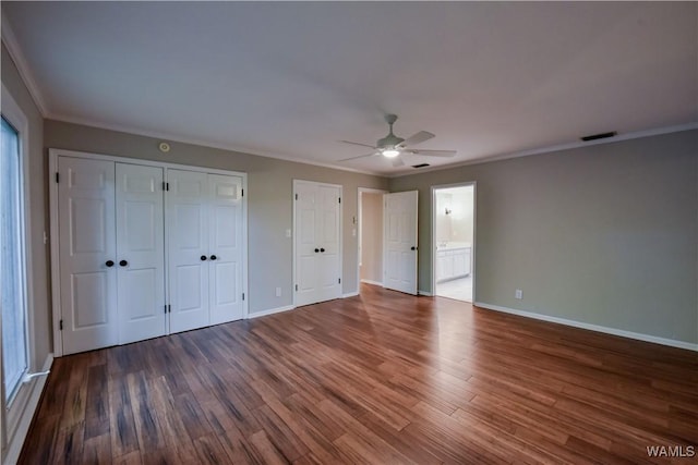 unfurnished bedroom featuring visible vents, wood finished floors, baseboards, and ornamental molding