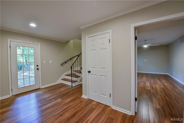 foyer featuring stairs, wood finished floors, baseboards, and a ceiling fan