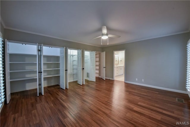 unfurnished bedroom featuring visible vents, baseboards, dark wood-style flooring, and crown molding