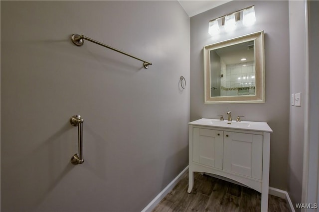 bathroom featuring vanity, wood finished floors, and baseboards