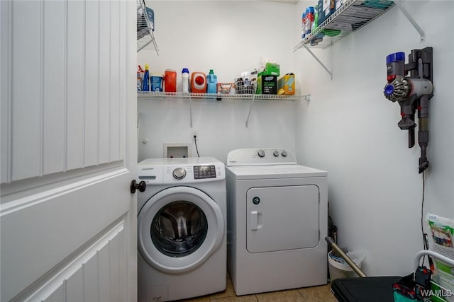 laundry area featuring washer and dryer, laundry area, and light tile patterned floors