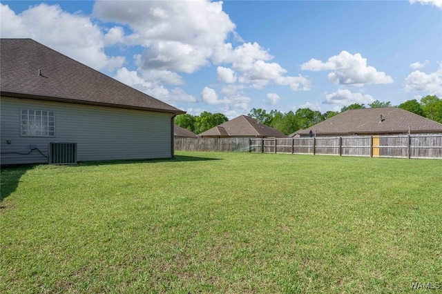 view of yard with a fenced backyard and central AC unit