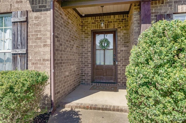 doorway to property featuring brick siding