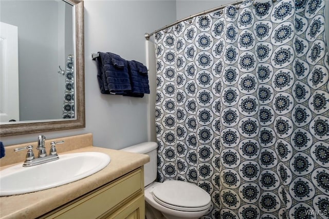 bathroom with curtained shower, toilet, and vanity