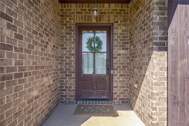 view of exterior entry with brick siding