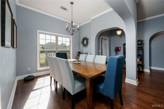 dining area featuring crown molding, arched walkways, a chandelier, and dark wood-style flooring