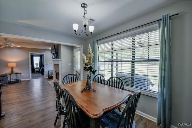 13024 Brookview Way, Northport, AL 35473 - dining area featuring ceiling fan with notable chandelier, baseboards, a tile fireplace, visible vents, and dark wood-style floors