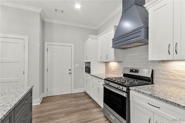 11480 Saint Joseph St, Northport, AL 35475 - kitchen featuring stainless steel gas range, custom range hood, ornamental molding, white cabinets, and light wood-style floors