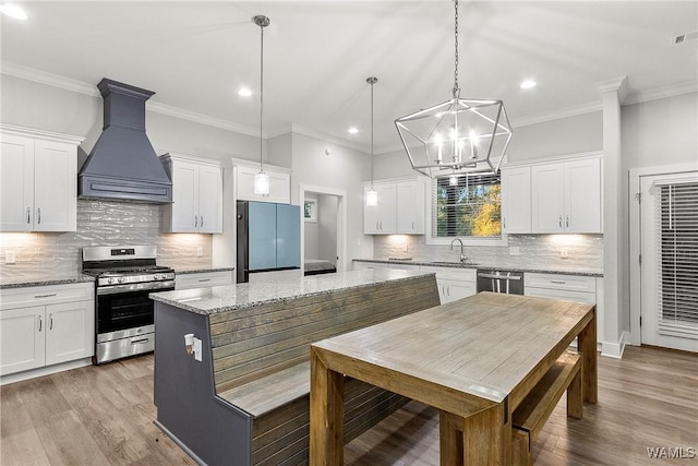 11480 Saint Joseph St, Northport, AL 35475 - kitchen with appliances with stainless steel finishes, custom exhaust hood, a sink, a center island, and recessed lighting