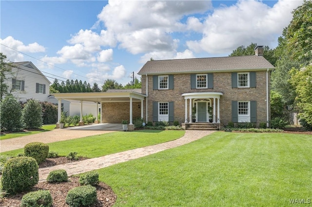 colonial-style house featuring a front yard and a carport