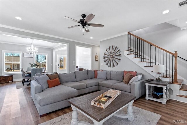 living area featuring recessed lighting, wood finished floors, visible vents, and stairs