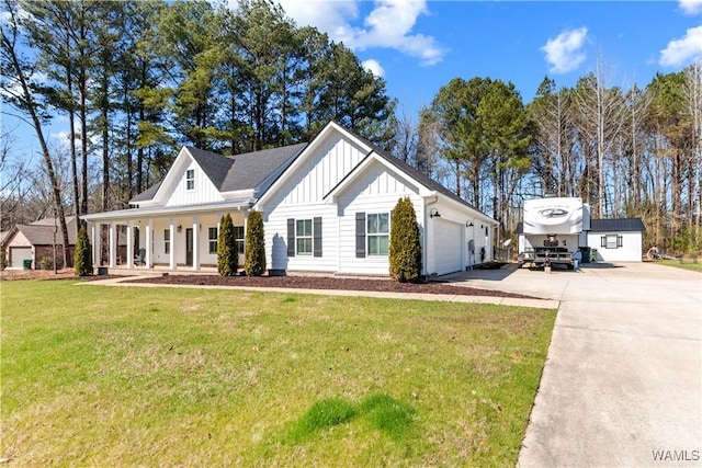 modern inspired farmhouse with a garage, concrete driveway, covered porch, a front lawn, and board and batten siding