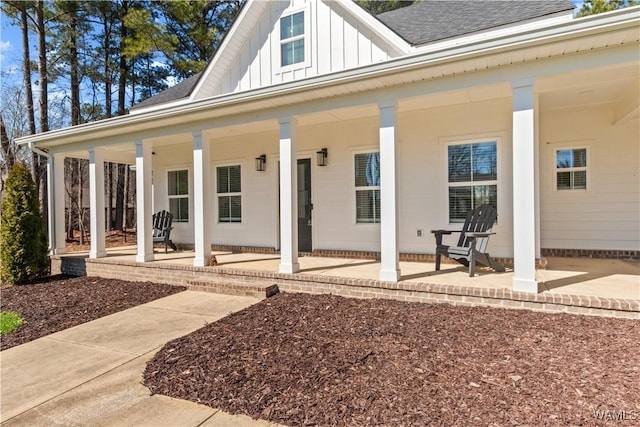 exterior space featuring board and batten siding and roof with shingles