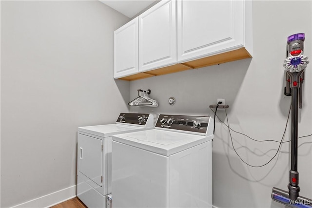 laundry room featuring separate washer and dryer, wood finished floors, cabinet space, and baseboards