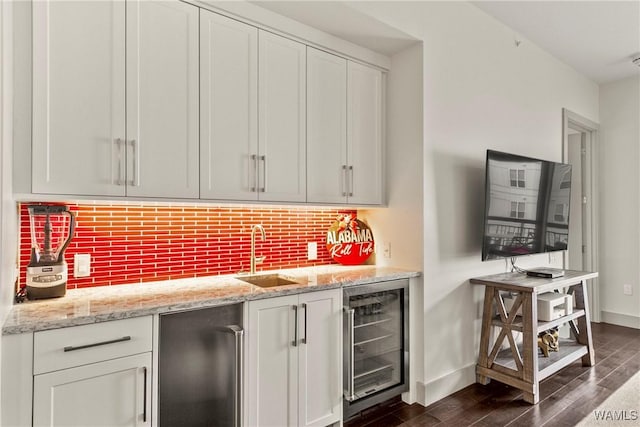 bar featuring beverage cooler, a sink, fridge, dark wood-style floors, and tasteful backsplash